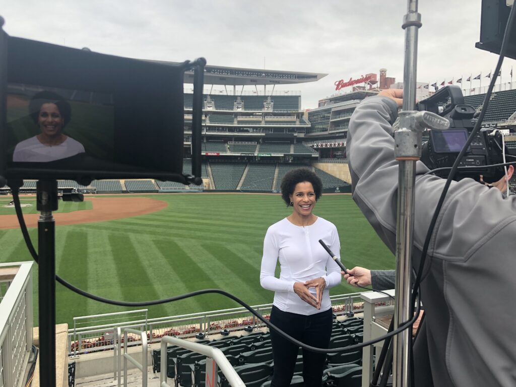 A woman is standing in the middle of an outdoor field.